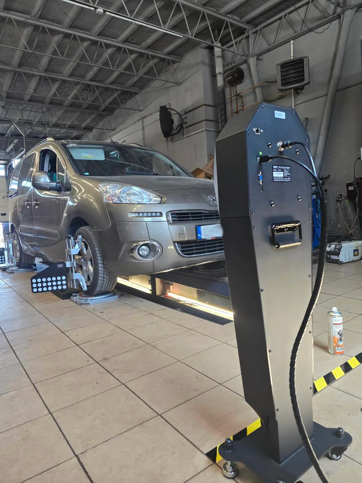Citroën Berlingo srebrny na podnośniku 4-kolumnowym podczas pomiaru geometrii FCAR FD-505 – Tiger Serwis