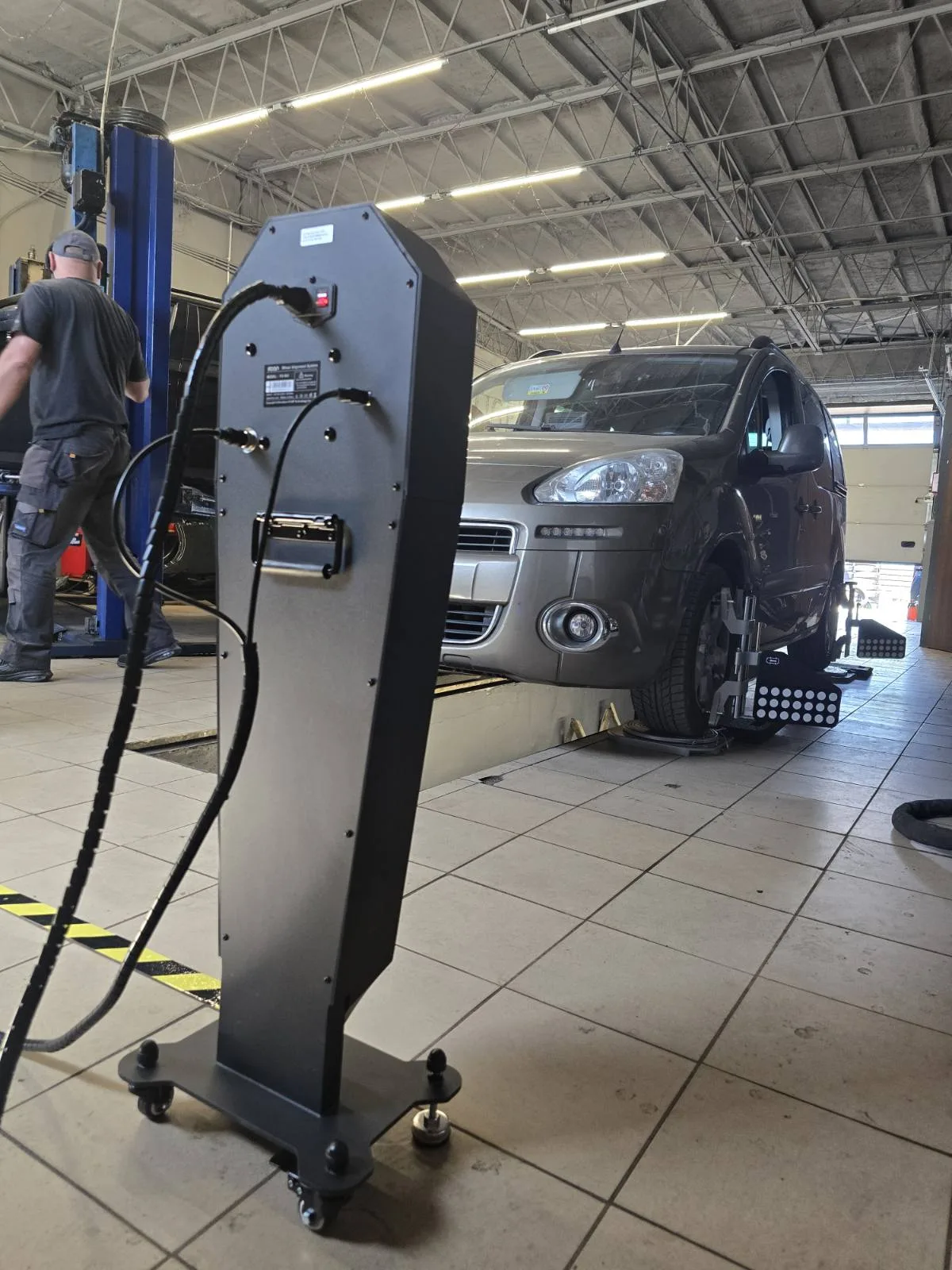 Pomiar geometrii kół na stanowisku z podnośnikiem 2-kolumnowym – mechanik Tiger Serwis przy pracy